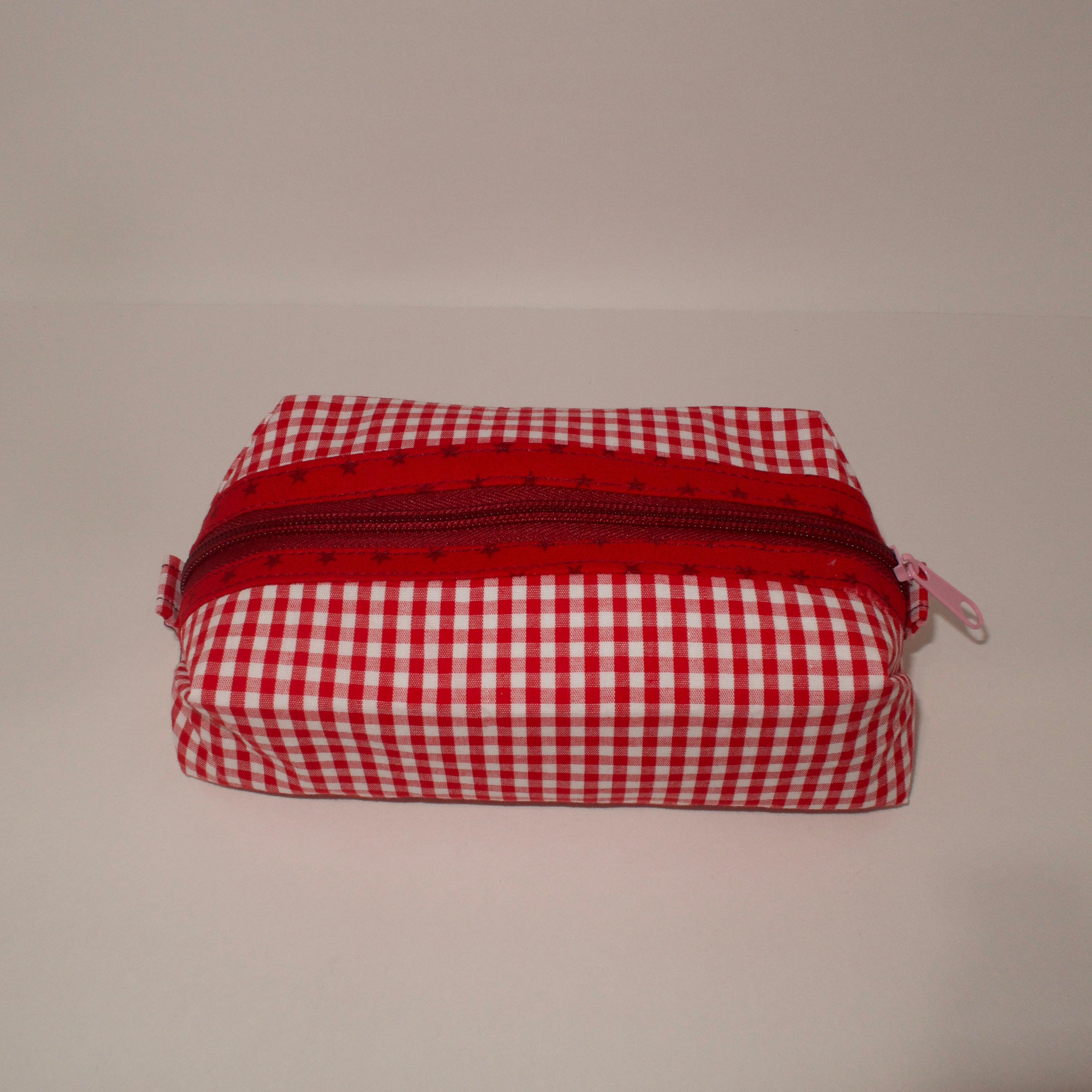 Red and white checkered pouch with a zipper on a white background