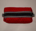 Red fabric pouch with black and white checkered zipper on a beige background
