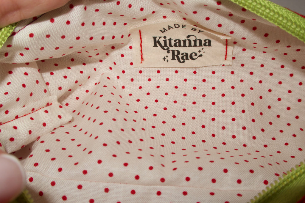 Close-up of a polka dot fabric with 'Kitanna Rae' brand label.