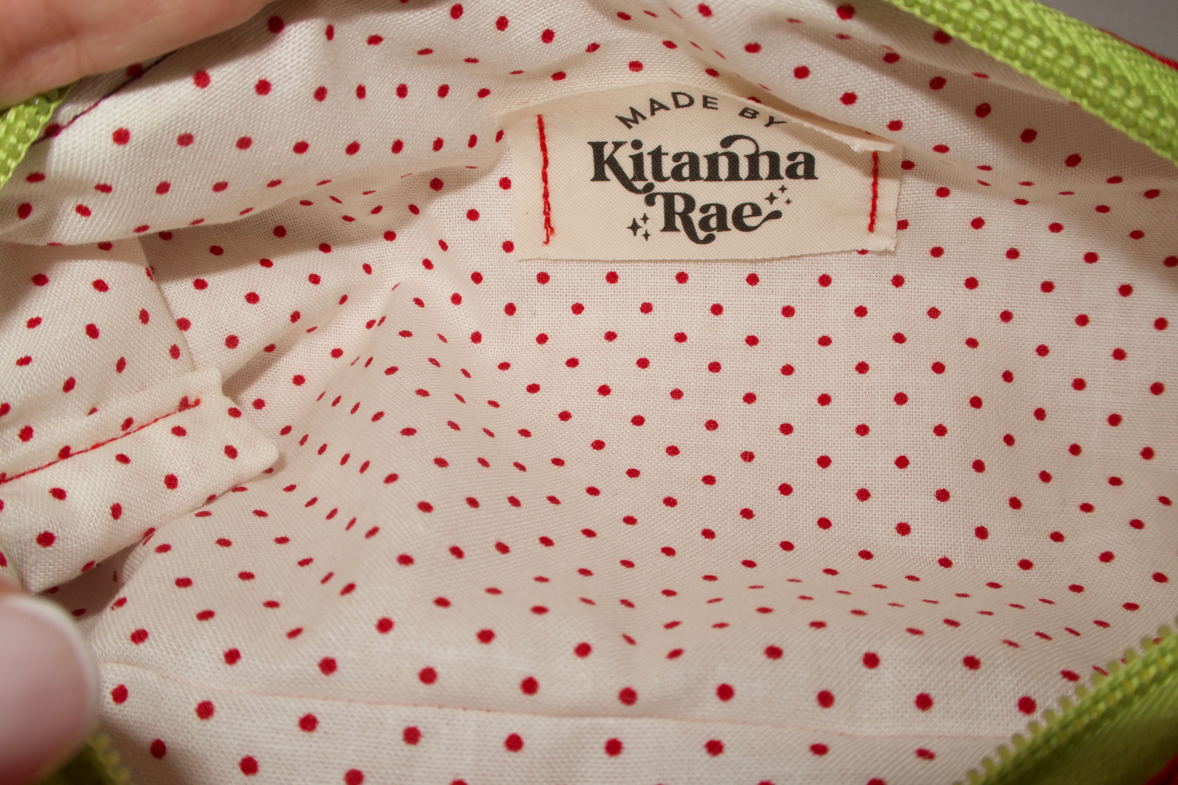 Close-up of a polka dot fabric with 'Kitanna Rae' brand label.