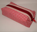 Red and white checkered pencil case with a red zipper on a light gray background