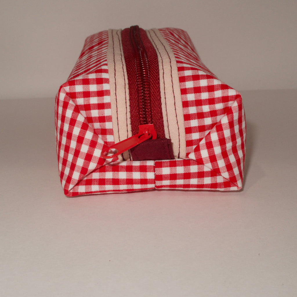 Red and white checkered pouch with a zipper on a gray background