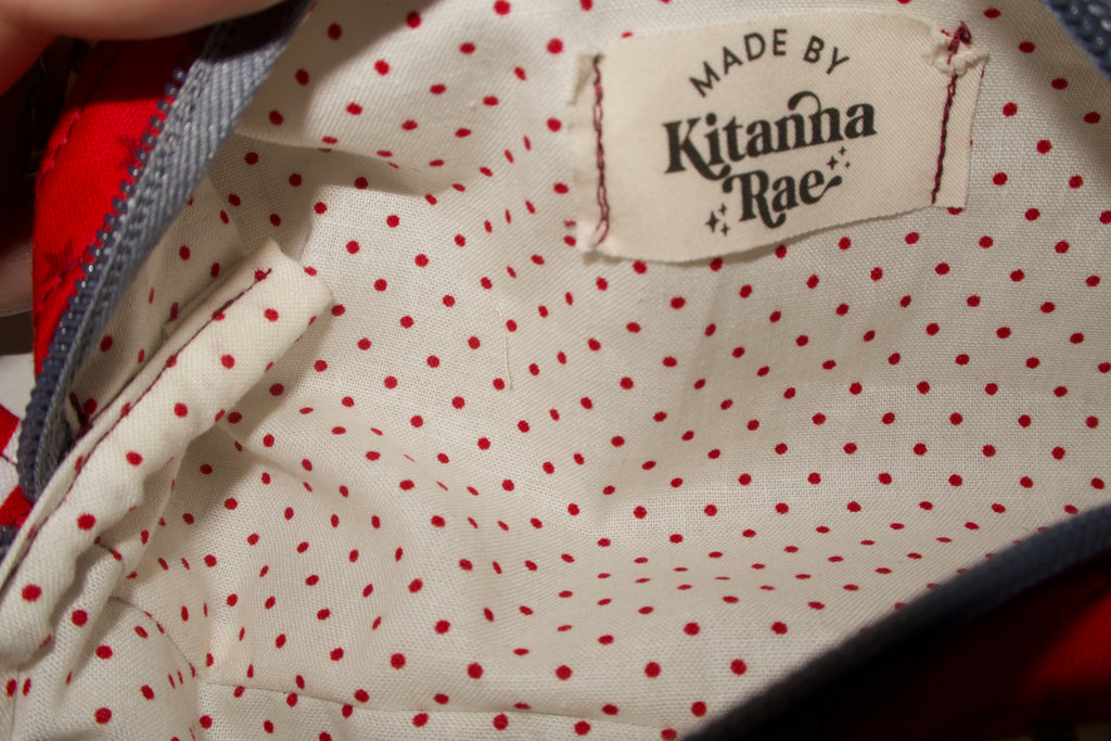 Close-up of a garment with red polka dots and a 'Made by Kitanna Rae' label.