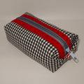 Checkered pouch with red and gray zipper on a beige background