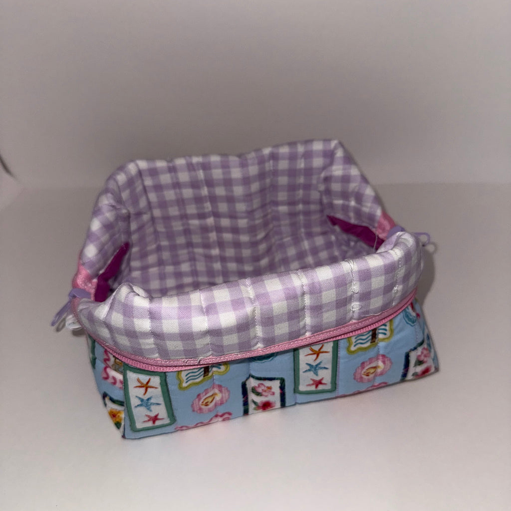 Two fabric items, one checkered and one with colorful patterns, on a white background.
