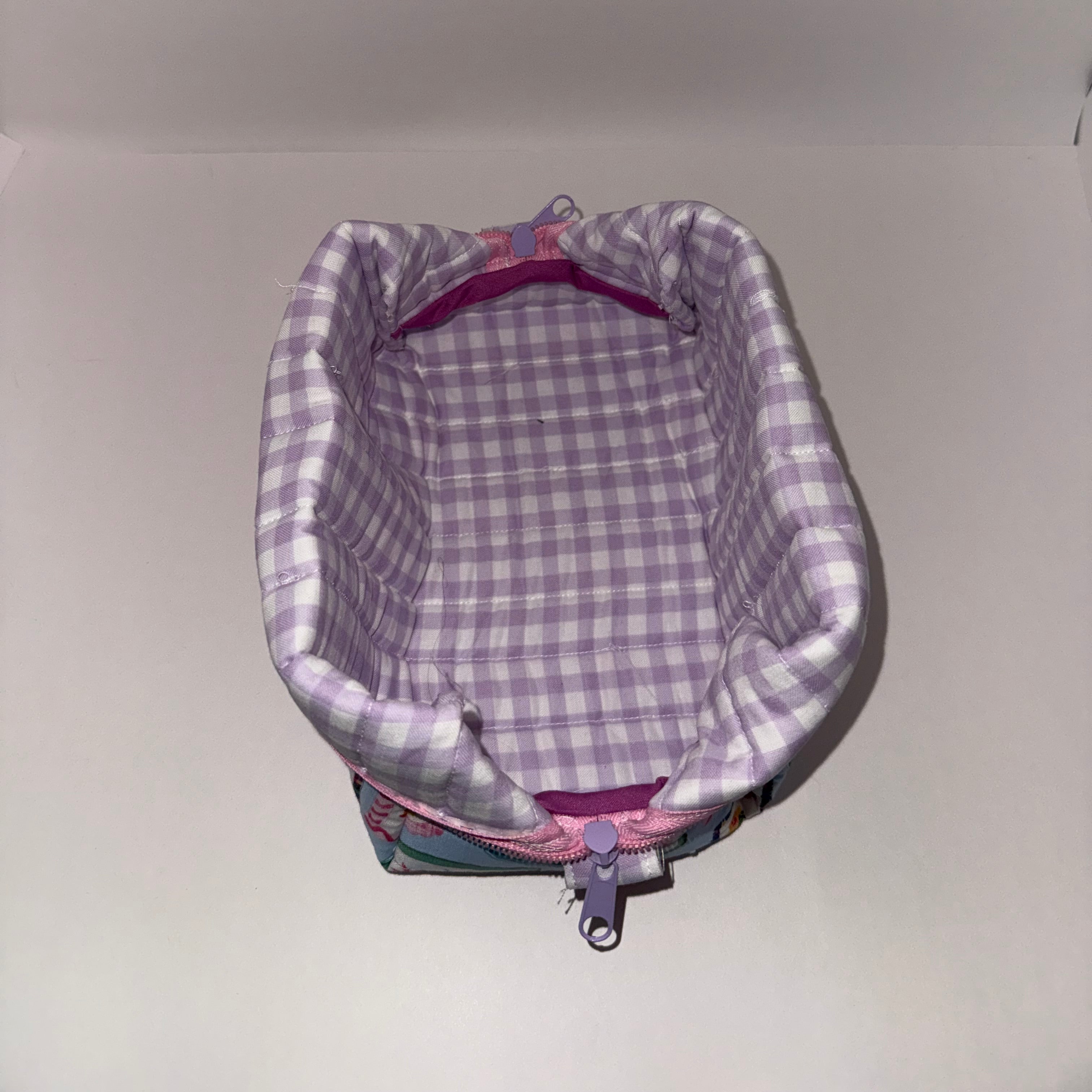 Backpack with purple and gray checkered interior on a plain background