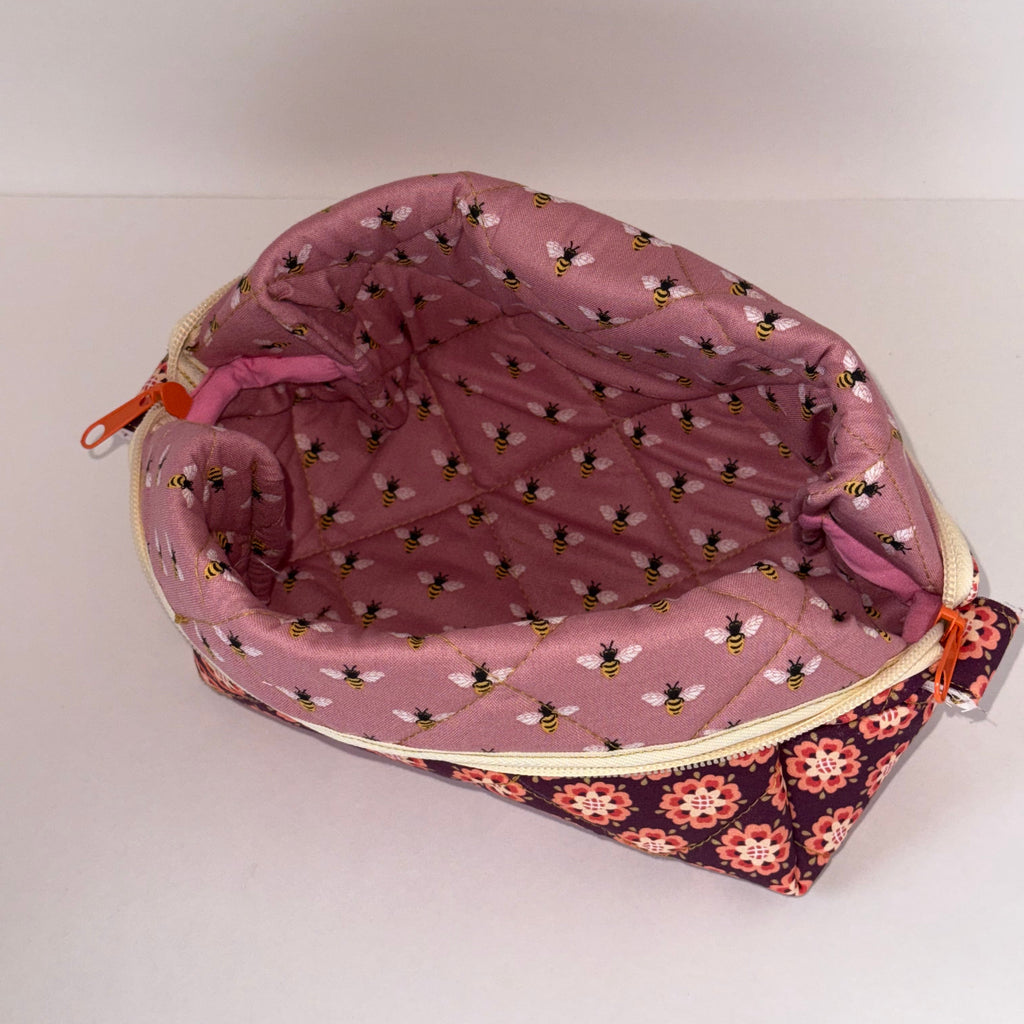 Pink pouch with bee pattern on a white background